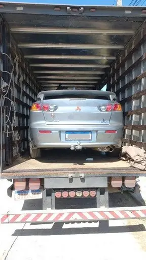 Carro transportado com segurança dentro do baú do caminhão